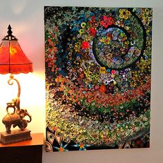 a lamp next to a painting on a wall with an elephant and flowered design