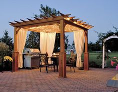 a gazebo sitting on top of a brick patio next to a table and chairs