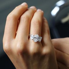 a woman's hand holding an engagement ring