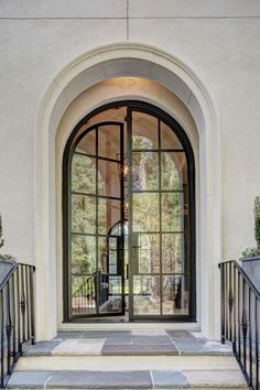 an open door on the outside of a house with glass doors and wrought iron railings