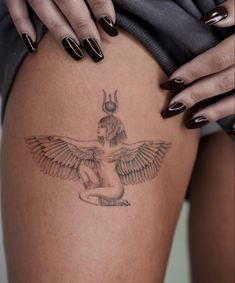 a woman's thigh with an egyptian winged tattoo on her leg and the bottom part of her thighs