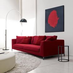 a living room with a red couch and white rug