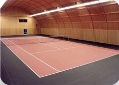 an indoor tennis court with wooden walls and ceiling