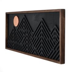 a black and brown wall hanging with mountains on it