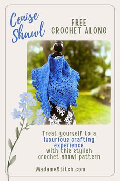 the crochet shawl is on display in front of a white frame with blue flowers