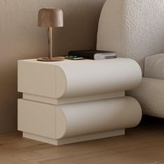 a white nightstand with a lamp on top of it