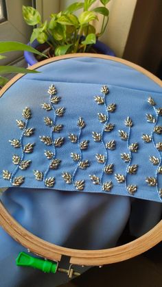 a close up of a blue cloth with silver flowers on it and a wooden frame