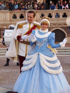 a man and woman dressed up as cinderella and prince charmingly dancing in front of a crowd