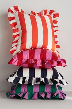 a stack of pillows sitting on top of each other in front of a white wall