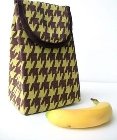 a yellow banana sitting next to a brown and white bag