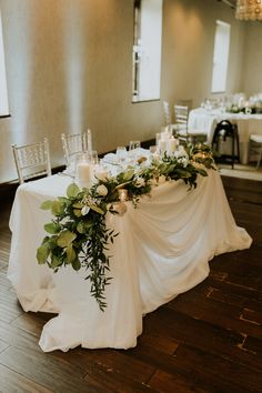 the table is set up with candles and greenery for an elegant wedding breakfasteon