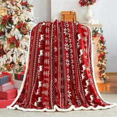 a red and white blanket sitting next to a christmas tree