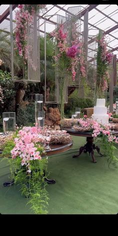 a table topped with cake and flowers in a greenhouse