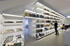 a person standing in front of a bookshelf filled with lots of different types of books