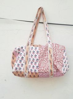 a pink and white bag hanging on a wall