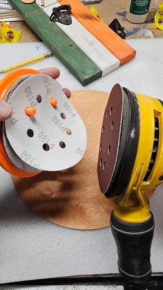 a person using a sanding disc on a wooden board