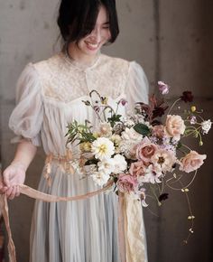 a woman holding a bouquet of flowers in her hands