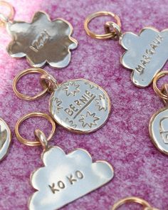 brass flower and cloud shaped pet tags with engraved dogs and cats names lay on a pink backdrop.

brass, pet tag, pet tags, dog tags, handmade, ethically made, unique, original, fun, cute, cloud, shapes, solid brass, metal, ID, Pet identification, personalised, personal, engraved, carved, small brand, bespoke, nighttimeholiday, ralf, whippet, sustainably made, ethical Dog Tag Display, Stamped Dog Tags, Cute Names For Dogs, Dog Accesories, Dog Name Tags, Modern Pet, Dog Id Tags, Cat Accessories, Tag Design