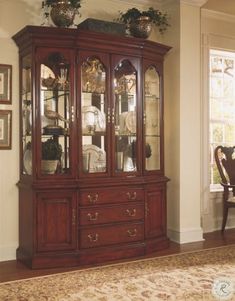 a large wooden china cabinet with glass doors