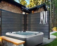 a hot tub sitting next to a wooden fence