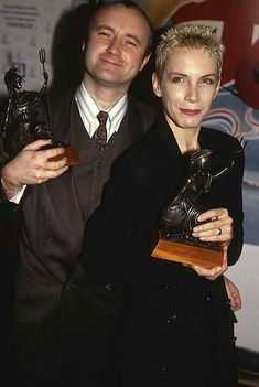 the man and woman are posing with their trophies