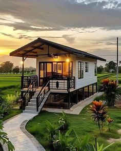 a small white house sitting on top of a lush green field