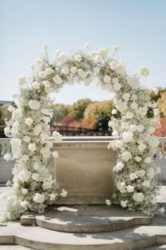 a white flowered arch on top of steps