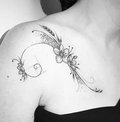 a black and white photo of a woman's back shoulder with flowers on it