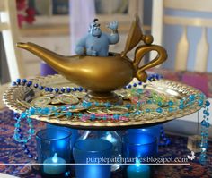 an elephant and baby elephant figurine sitting on top of a golden teapot