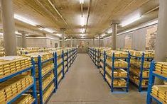 a large warehouse filled with lots of shelves and stacks of gold bars on blue racks