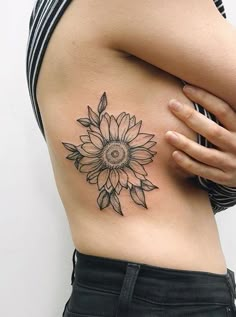 a woman with a sunflower tattoo on her stomach