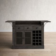 an old wooden table with wine bottles on it in front of a plain white wall