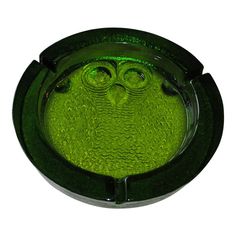 a green glass bowl with an owl face on it