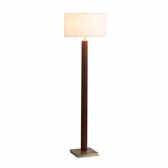 a floor lamp with a white shade on the top and a brown base, against a white background