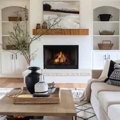 a living room filled with furniture and a fire place in the middle of the room