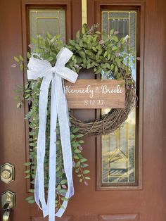 the front door is decorated with a wreath and welcome sign