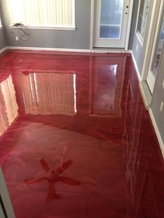 a red floor in a room with white doors and windows on either side of the door