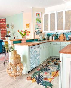 the kitchen is decorated in pastel colors and has an area rug on the floor