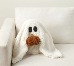 a white couch with a stuffed animal on it's face and eyes covered by a blanket