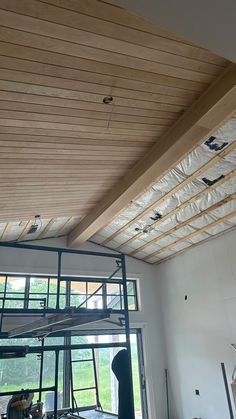 an unfinished ceiling in a large room with lots of windows