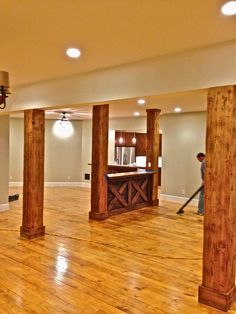 an empty living room with wood floors and columns