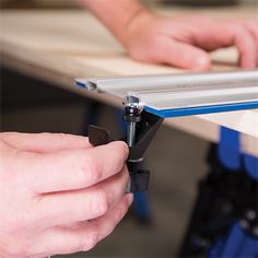 a person working on a piece of furniture with a pair of hands holding a tool