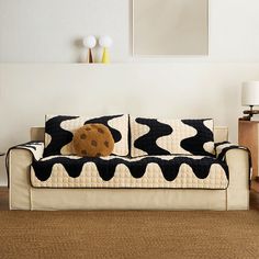 a black and white couch sitting on top of a wooden floor next to a lamp