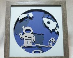 a paper cut out of an astronaut in front of the earth