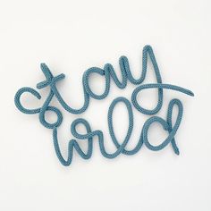 the word stay wild written in rope on a white surface with blue string attached to it