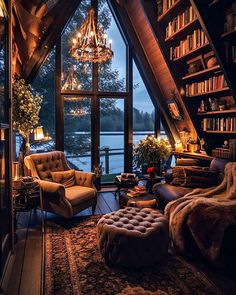 a living room filled with lots of furniture next to a tall book shelf covered in books