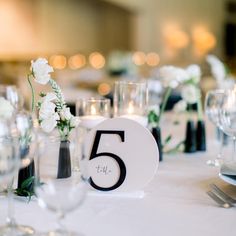 the table is set up with white flowers and silverware for an elegant wedding reception