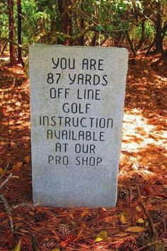 a memorial marker in the woods with pine cones around it that reads, you are 8 yards off line golf instruction available at our pro shop