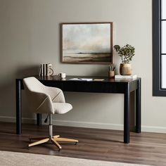 a desk with a chair and a painting on the wall