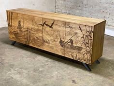 a wooden cabinet with an image of people in a boat and birds flying over the water